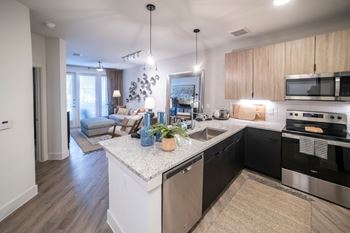 open floorplan kitchen with island and updated appliances at Station at Old Town, Lewisville